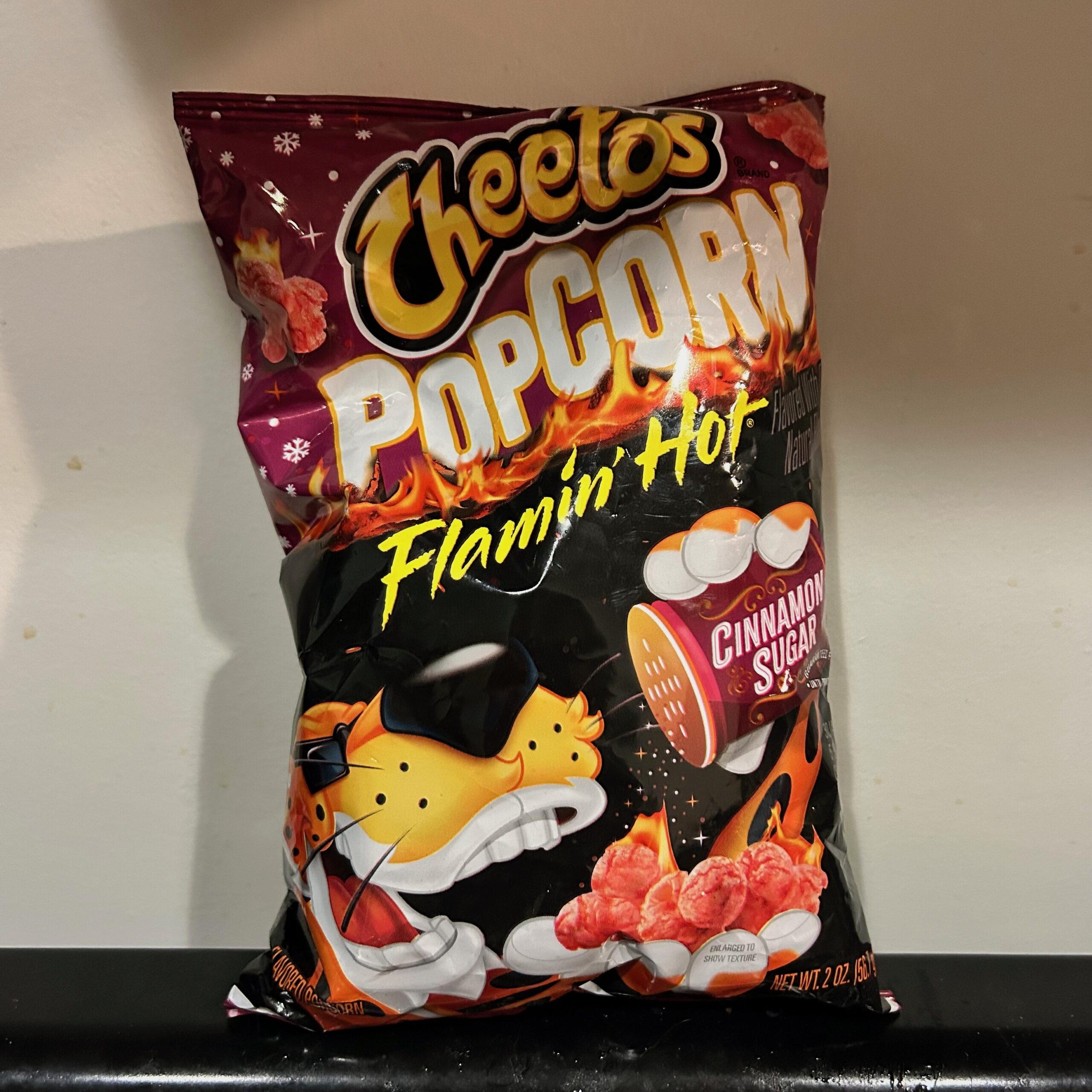 A bag of Cheetos popcorn flamin' hot cinnamon sugar against a white background.