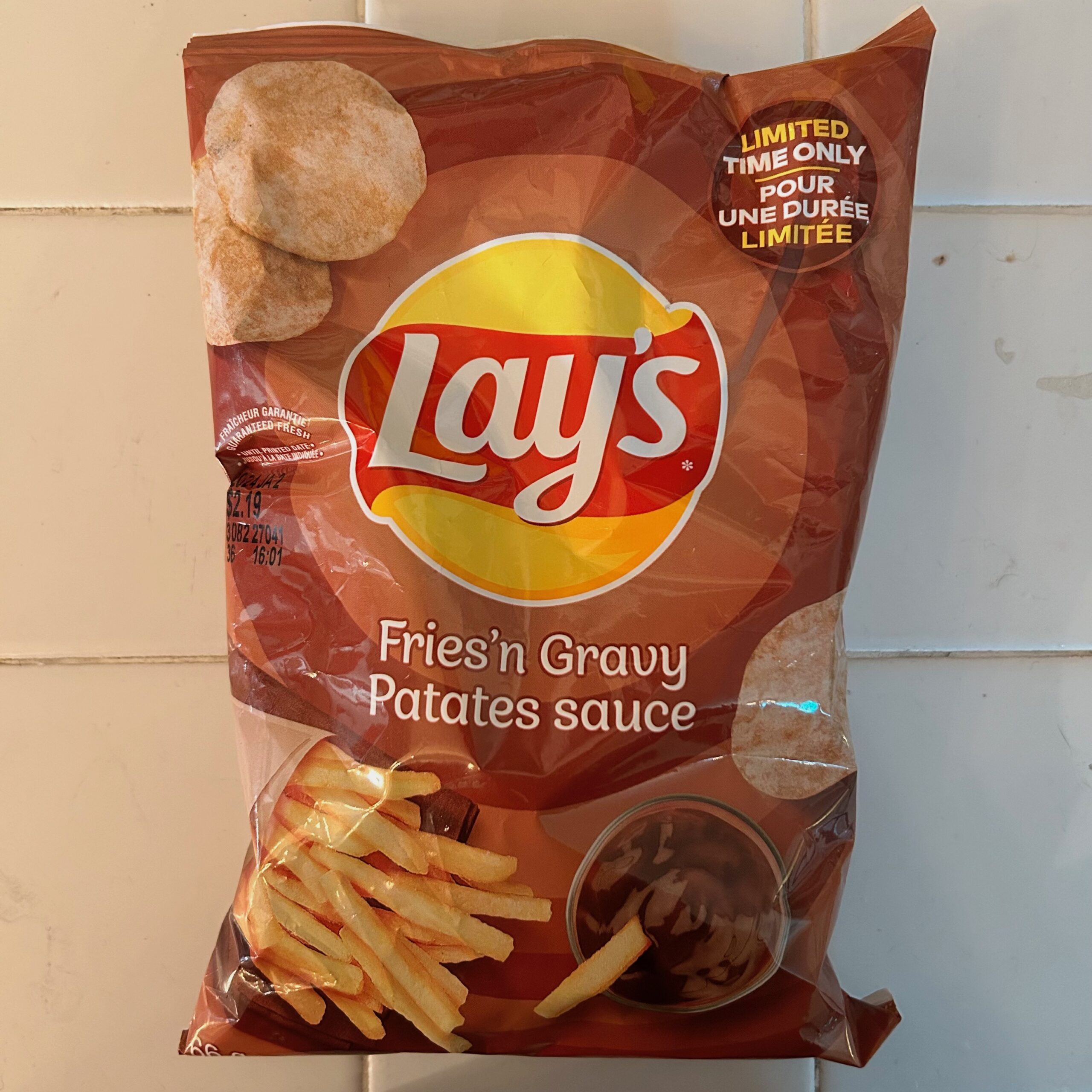 A white countertop and a brown bag which reads: Lay's Fries'n Gravy Patates sauce